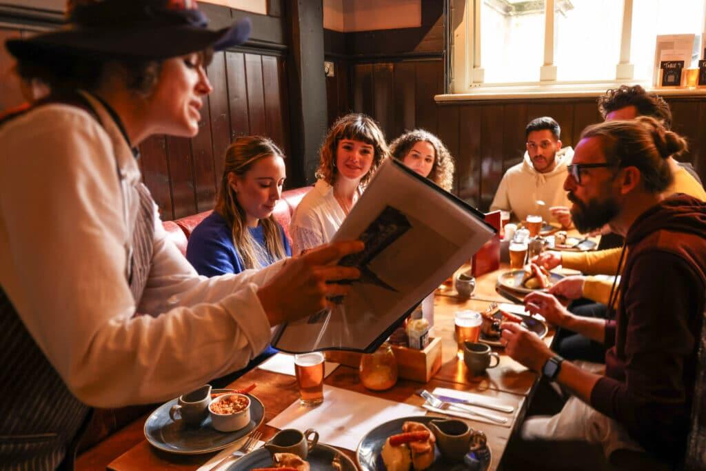 A guide explaining English food to the group at one of the tour stops